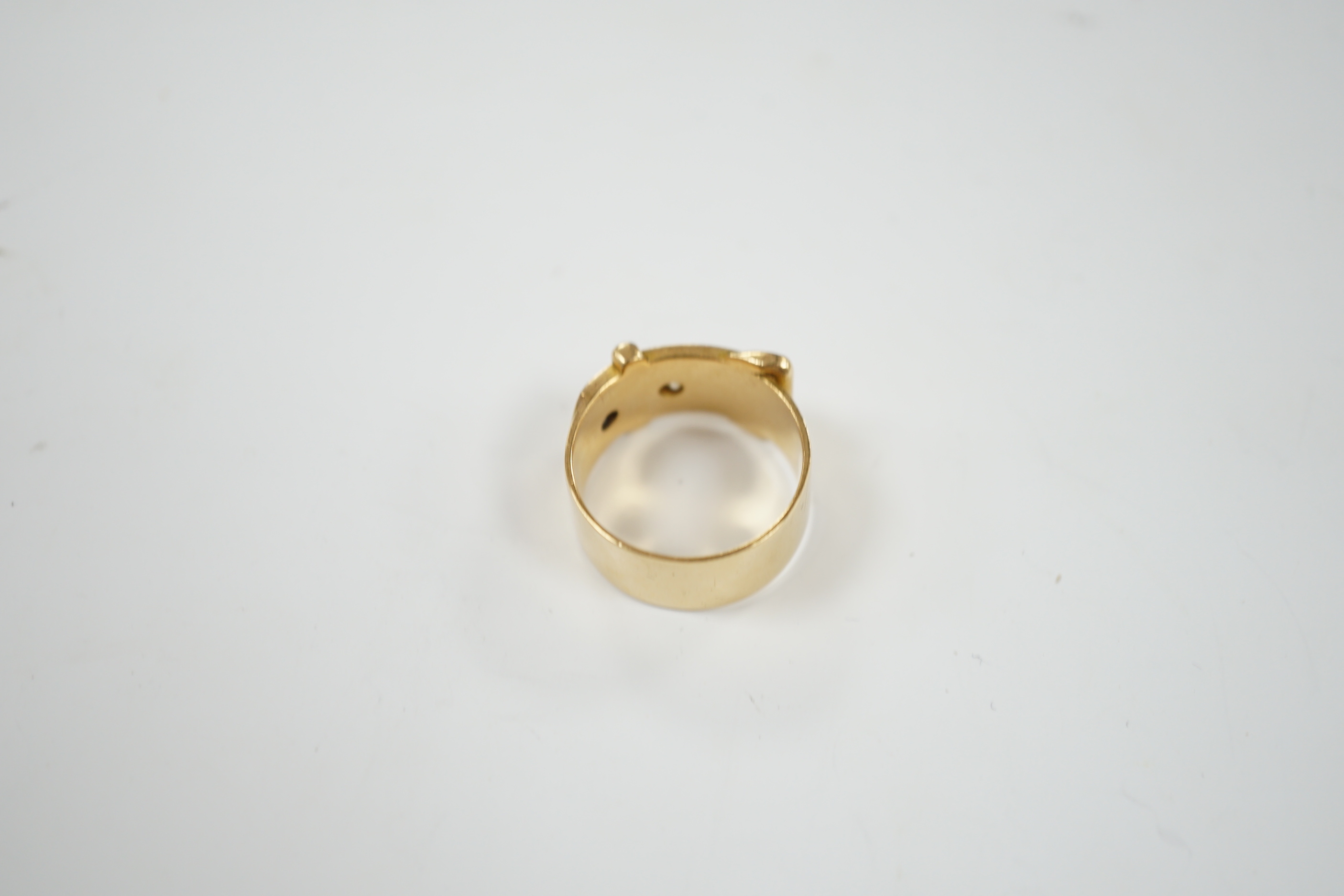 A George V 18ct gold and two stone diamond set buckle ring, size T, gross weight 11.9 grams.